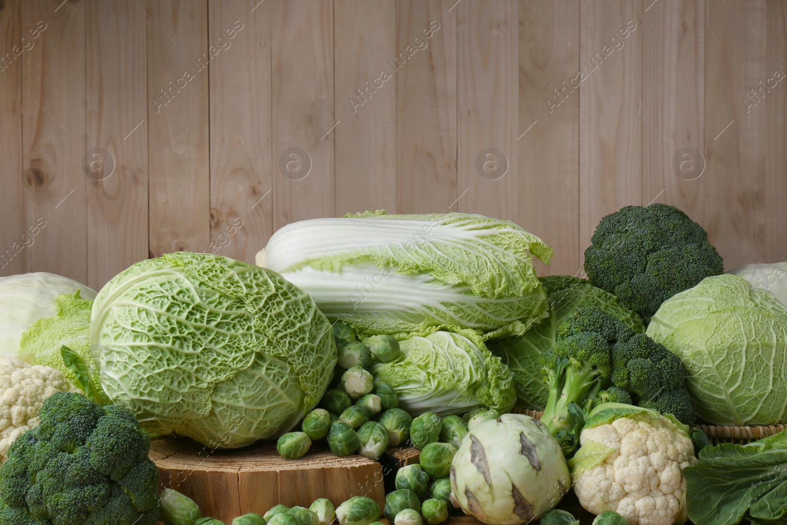 Photo of Many different types of fresh cabbage on wooden table