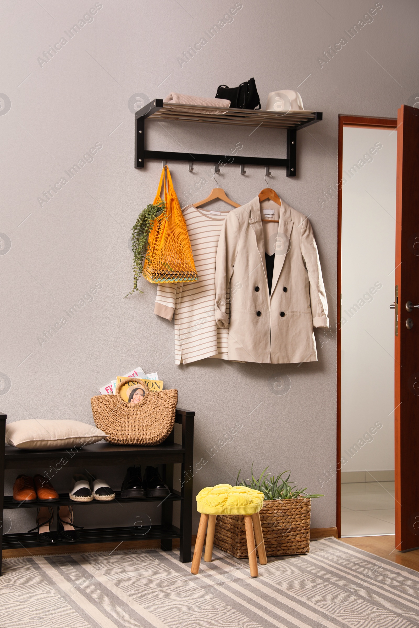 Photo of Hallway interior with stylish furniture, clothes and accessories