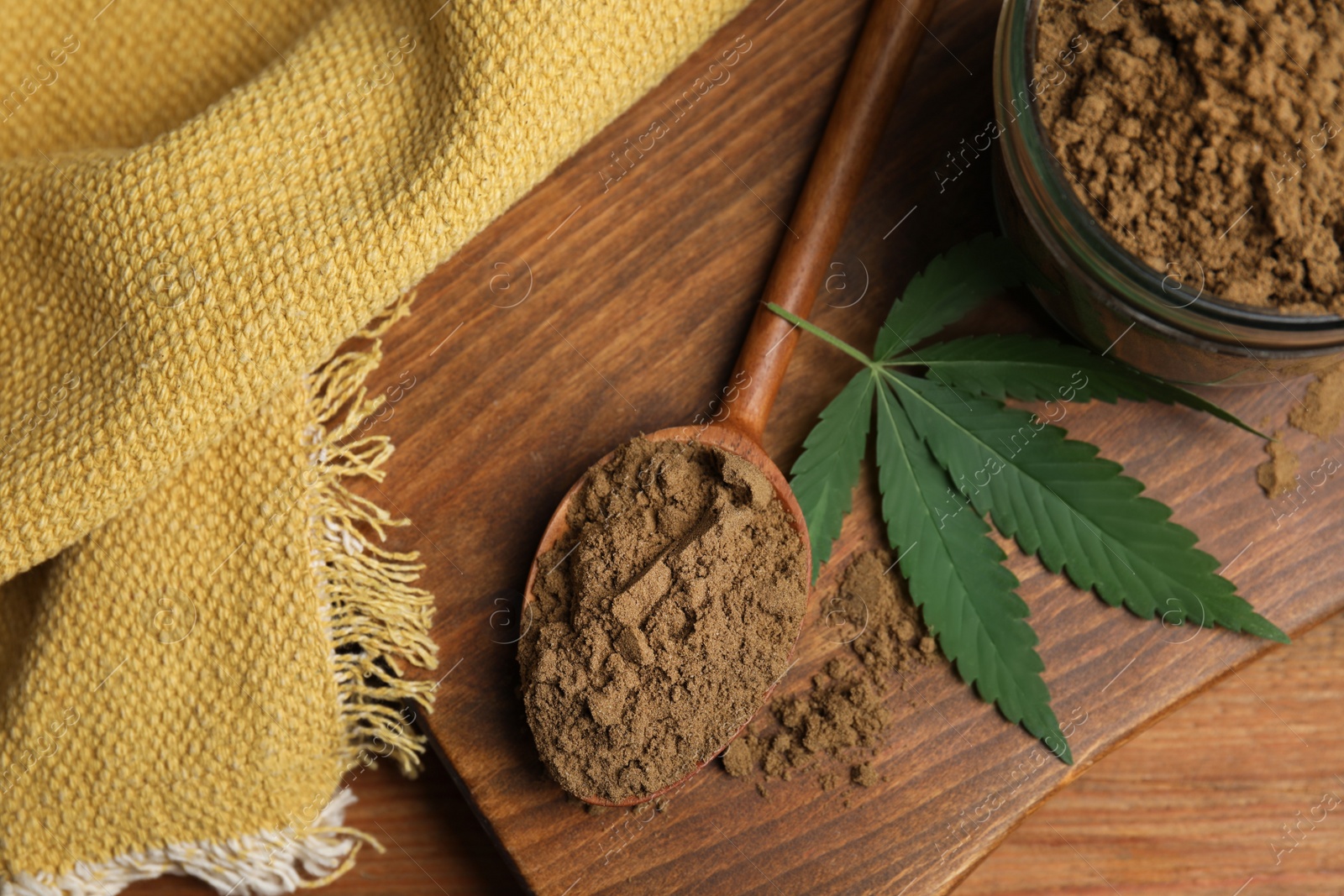 Photo of Hemp protein powder and fresh leaf on wooden table, flat lay