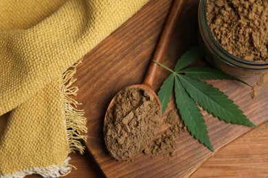 Hemp protein powder and fresh leaf on wooden table, flat lay