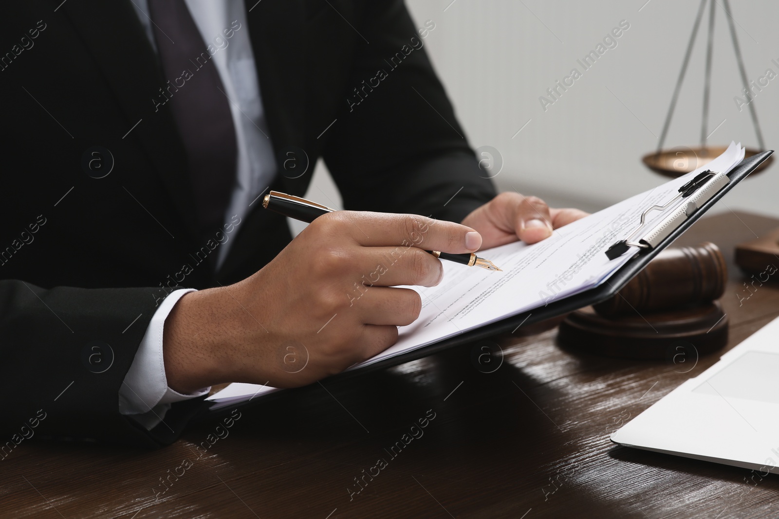 Photo of Law and justice. Lawyer working with documents at wooden table, closeup