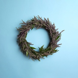 Beautiful heather wreath on light blue background, top view. Autumnal flowers