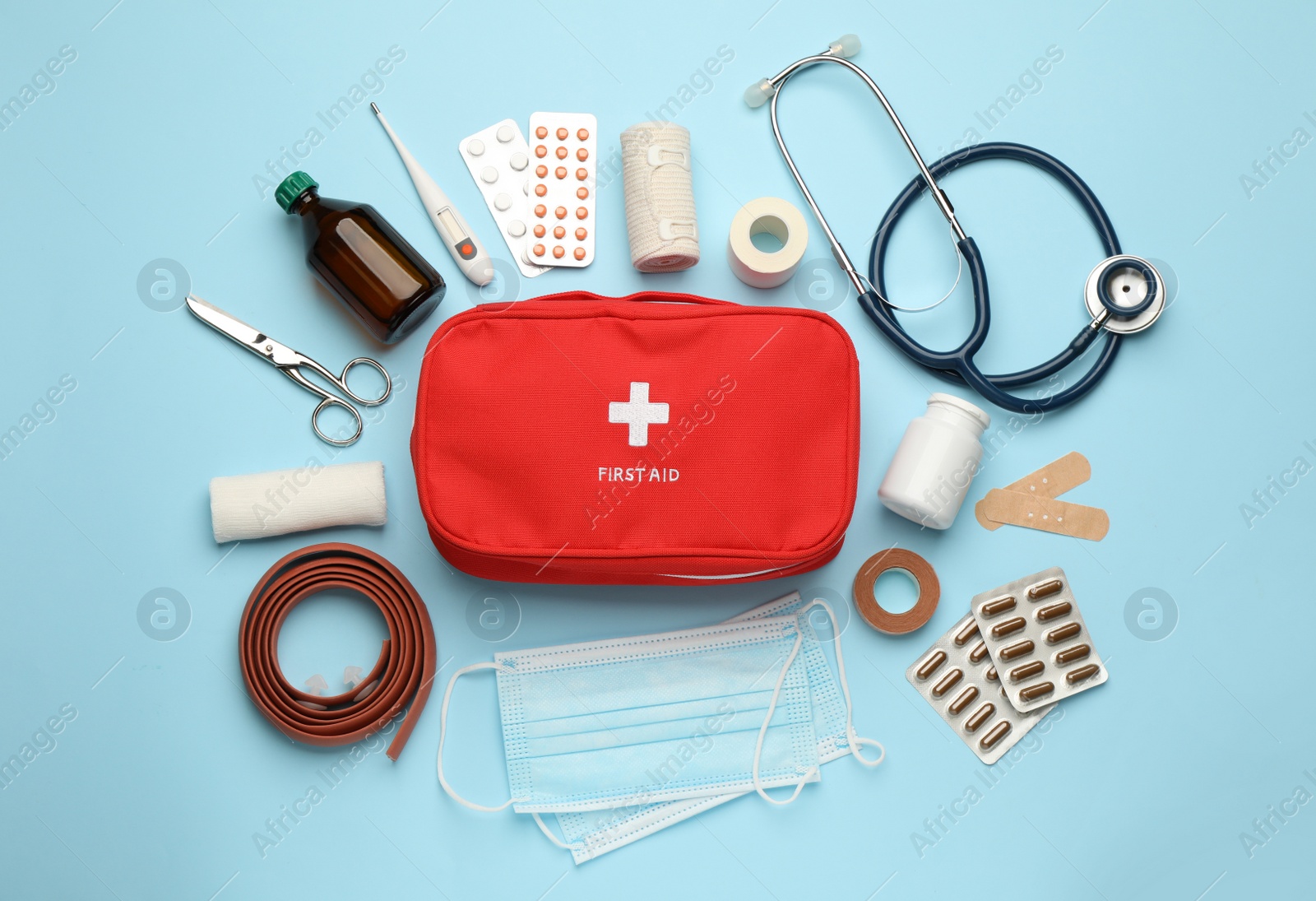 Photo of Flat lay composition with first aid kit on light blue background