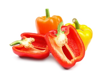 Whole and cut ripe bell peppers on white background