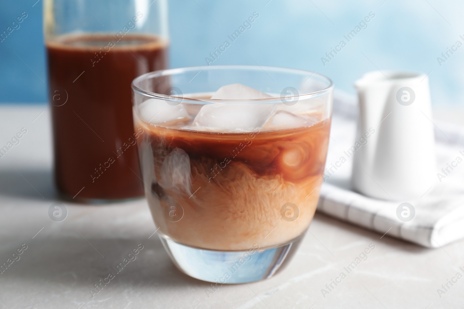 Photo of Glass with cold brew coffee and milk on table