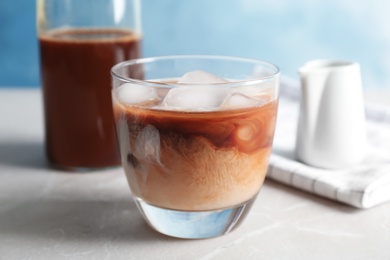 Photo of Glass with cold brew coffee and milk on table