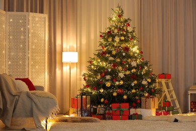 Photo of Beautifully wrapped gifts under Christmas tree in living room. Festive interior design