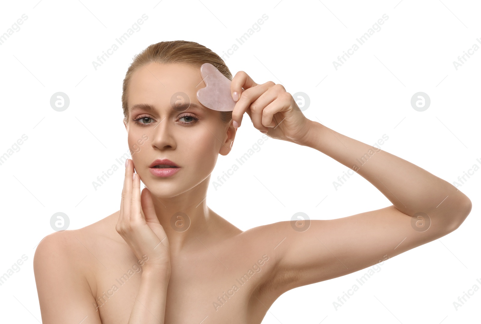 Photo of Beautiful young woman doing facial massage with gua sha tool on white background