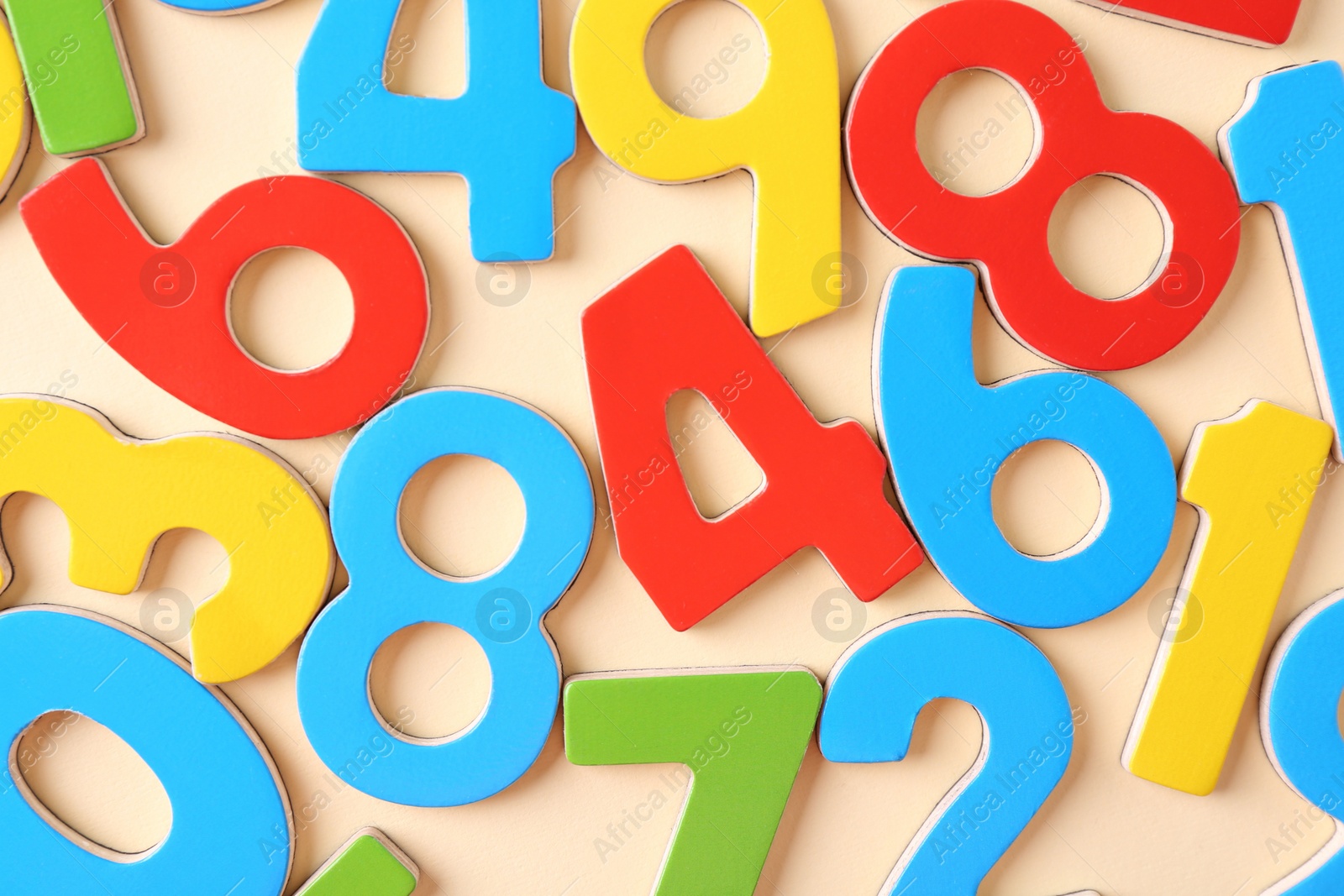 Photo of Colorful numbers on beige background, flat lay