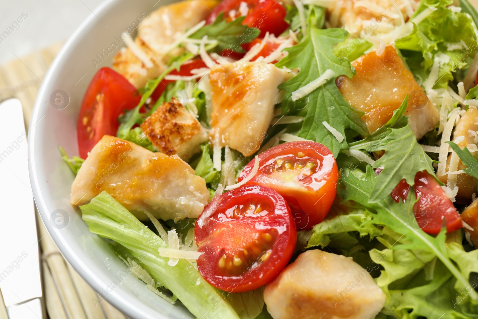 Photo of Delicious fresh Caesar salad in bowl, closeup