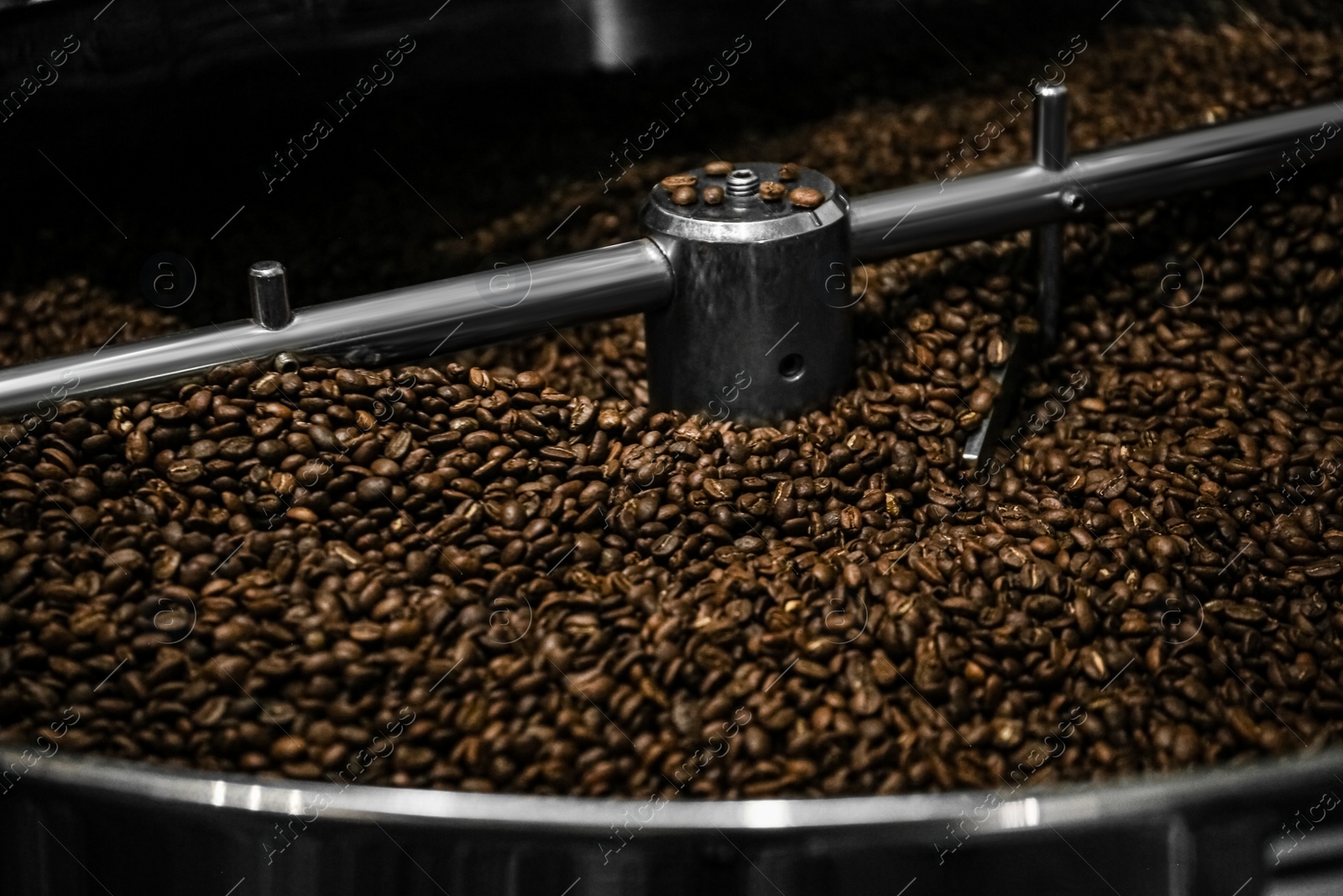 Photo of Modern coffee roaster machine with beans, closeup