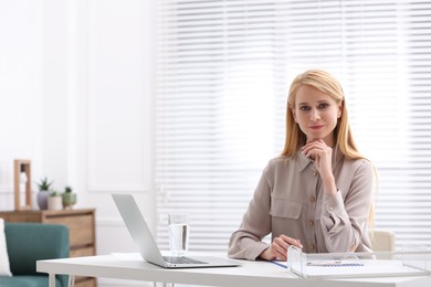 Professional lawyer working on laptop at table in office