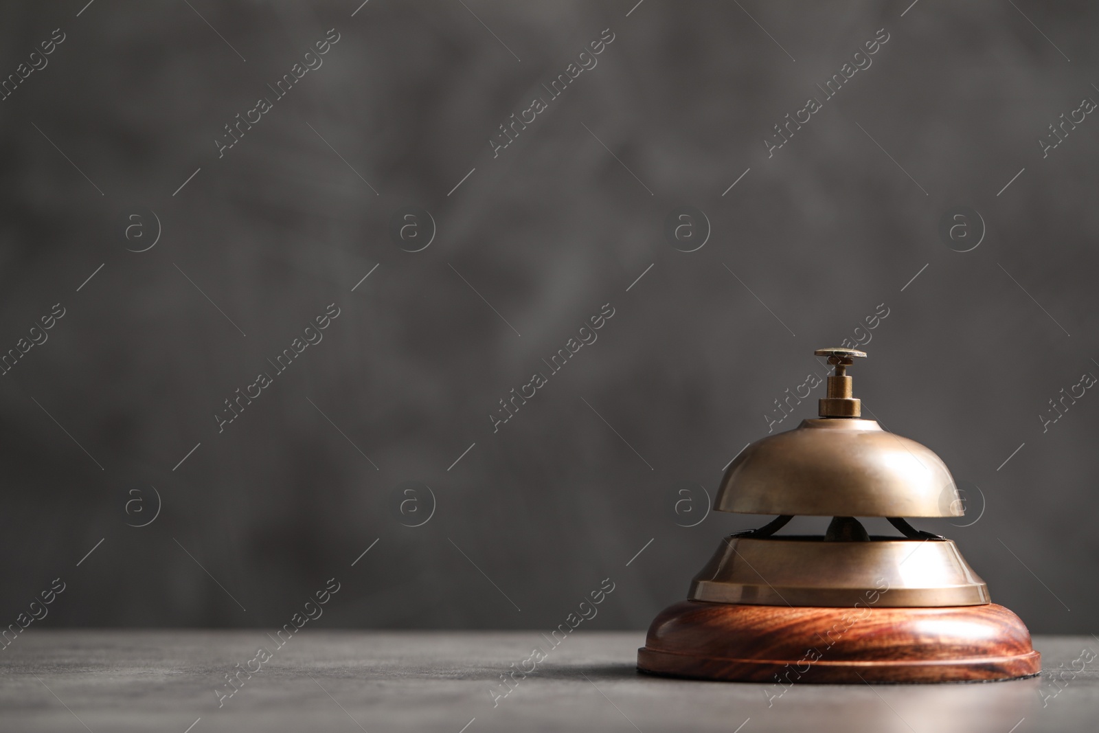 Photo of Hotel service bell on grey table. Space for text