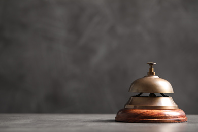 Photo of Hotel service bell on grey table. Space for text