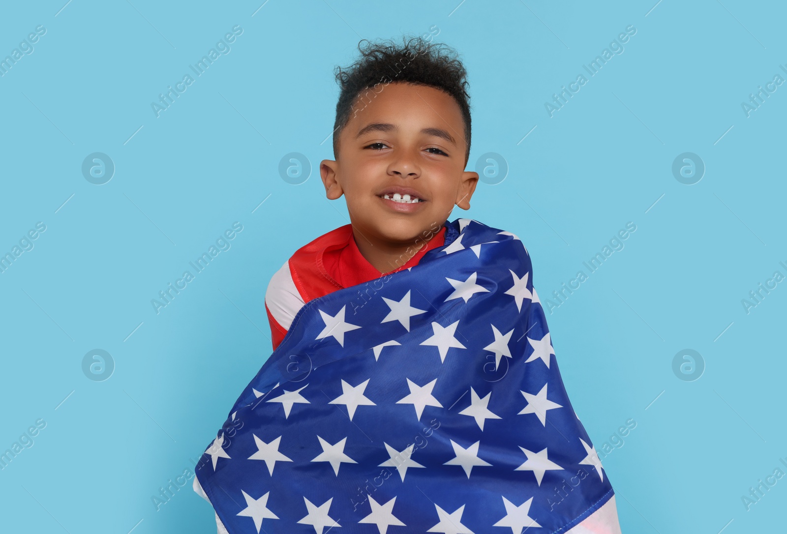 Photo of 4th of July - Independence Day of USA. Happy boy with American flag on light blue background