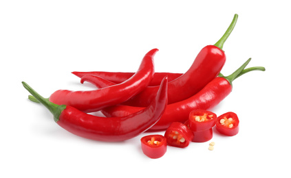 Photo of Cut and whole red hot chili peppers on white background