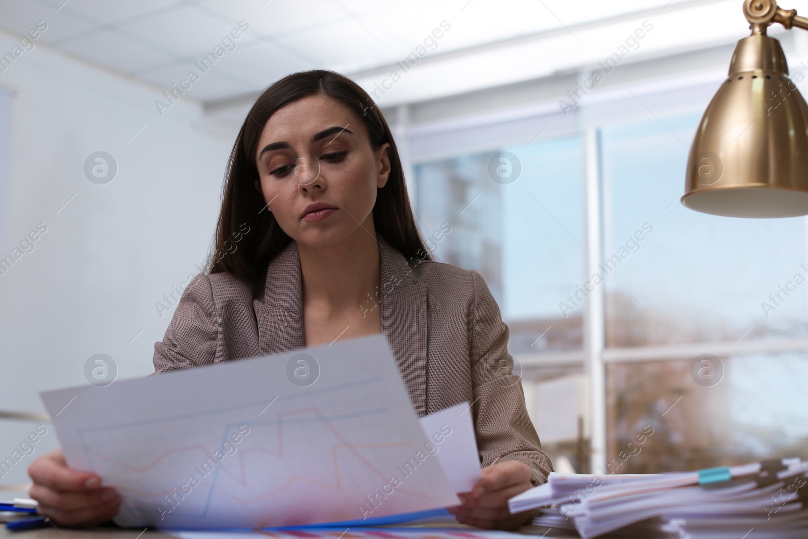 Photo of Businesswoman working with documents at table in office