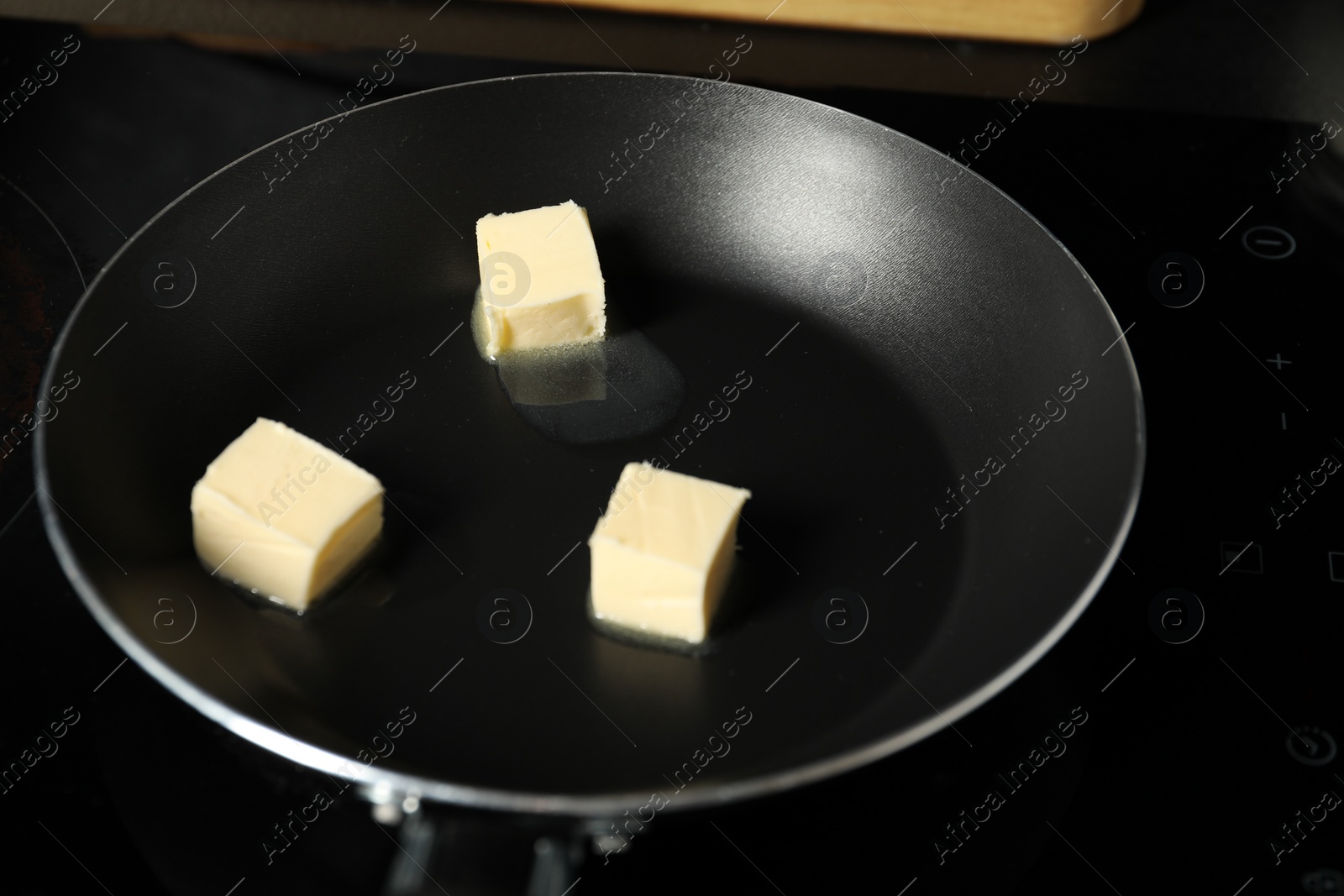 Photo of Melting butter in frying pan on cooktop, closeup