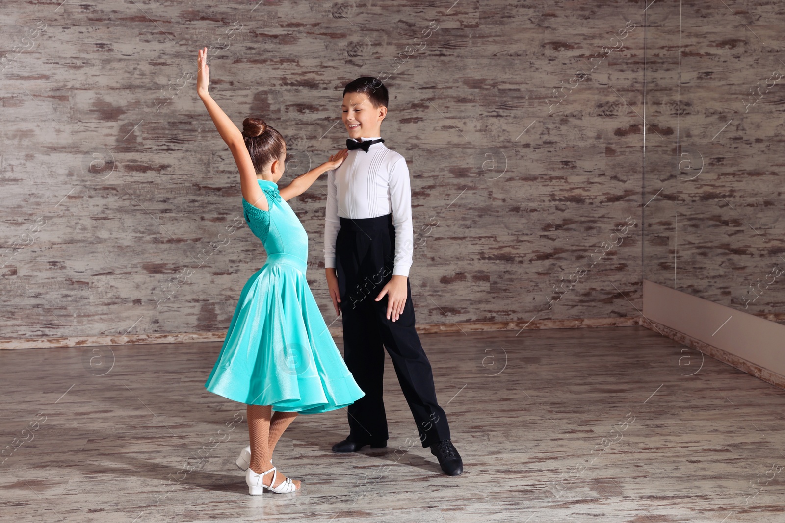 Photo of Beautifully dressed couple of kids dancing together in studio, space for text