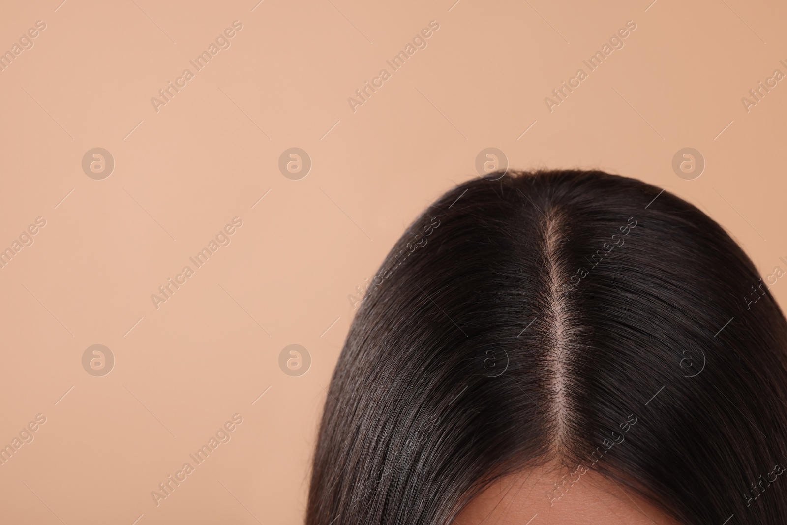 Photo of Woman with healthy hair on beige background, closeup. Space for text
