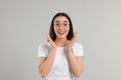 Photo of Surprised woman wearing glasses on light gray background