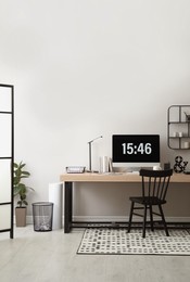 Photo of Modern workplace with computer in room. Interior design