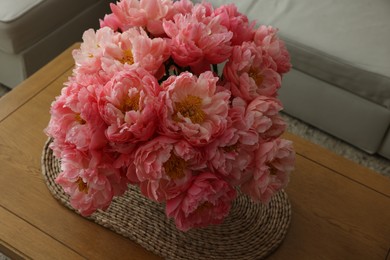 Beautiful pink peonies in vase on table indoors, above view
