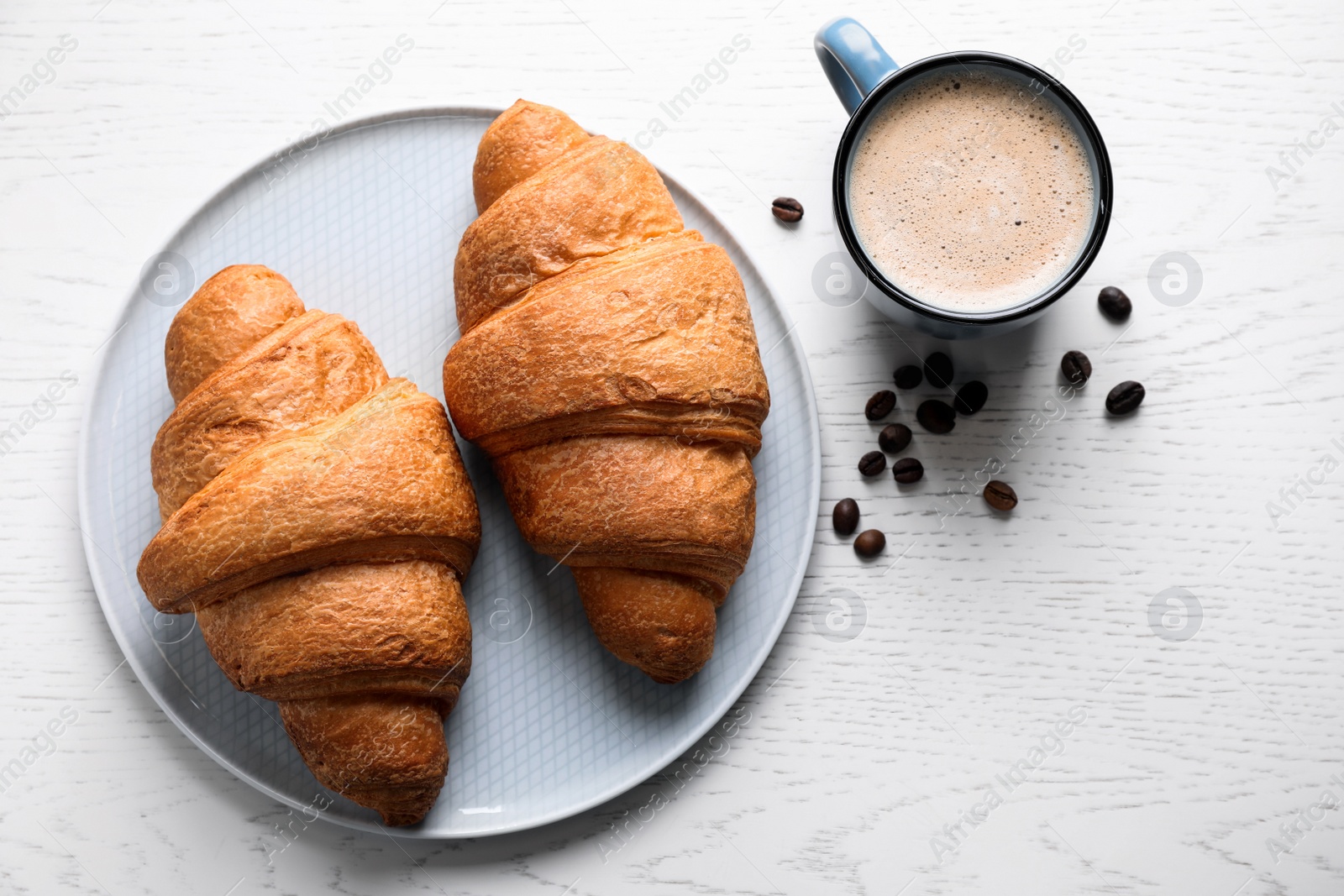Photo of Fresh croissants and coffee on white wooden table, flat lay