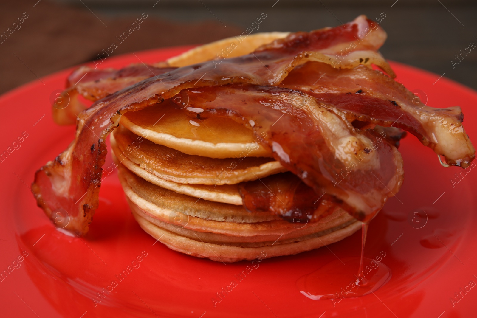 Photo of Delicious pancakes with bacon and honey on table, closeup