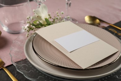 Photo of Stylish table setting. Plates, blank card and floral decor, closeup