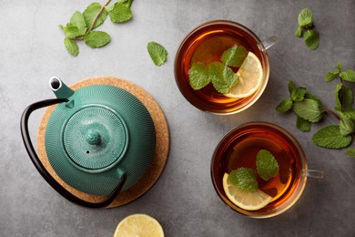 Aromatic herbal tea with mint and lemon on grey table, flat lay