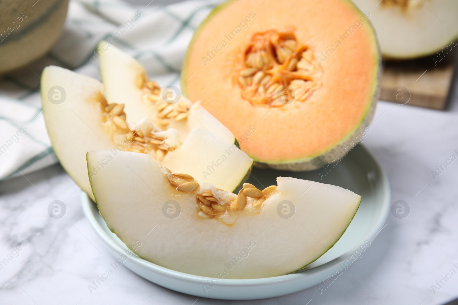 Photo of Tasty colorful ripe melons on white marble table, closeup