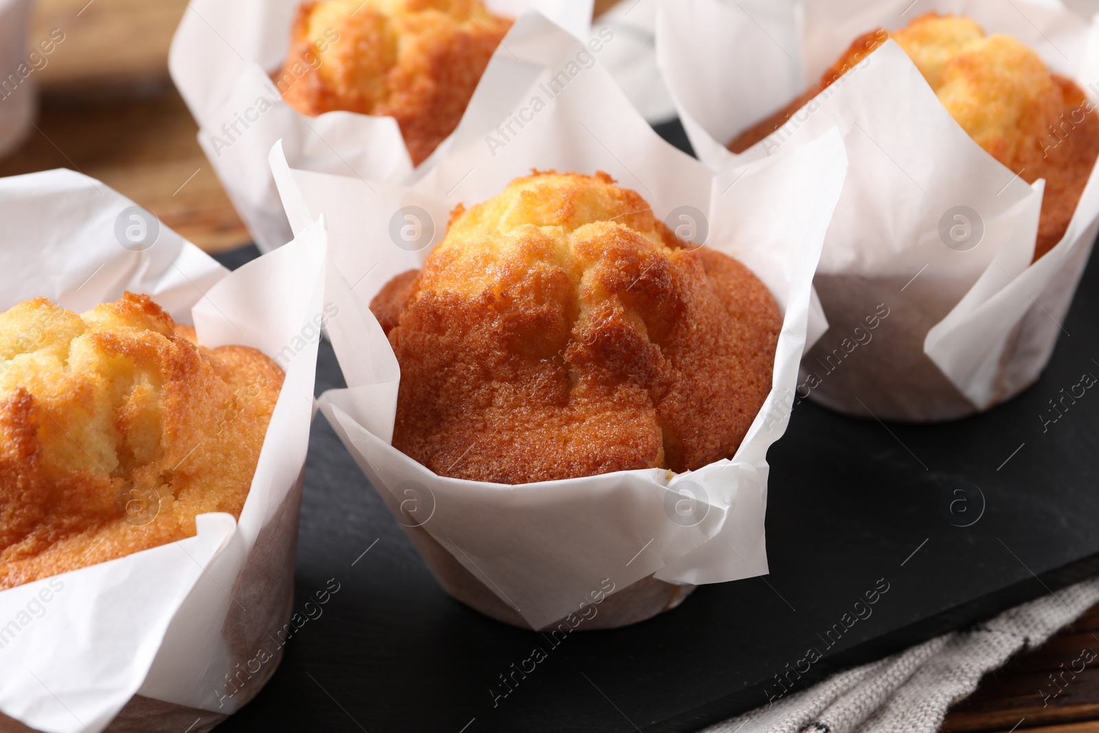 Photo of Delicious sweet muffins on wooden table, closeup