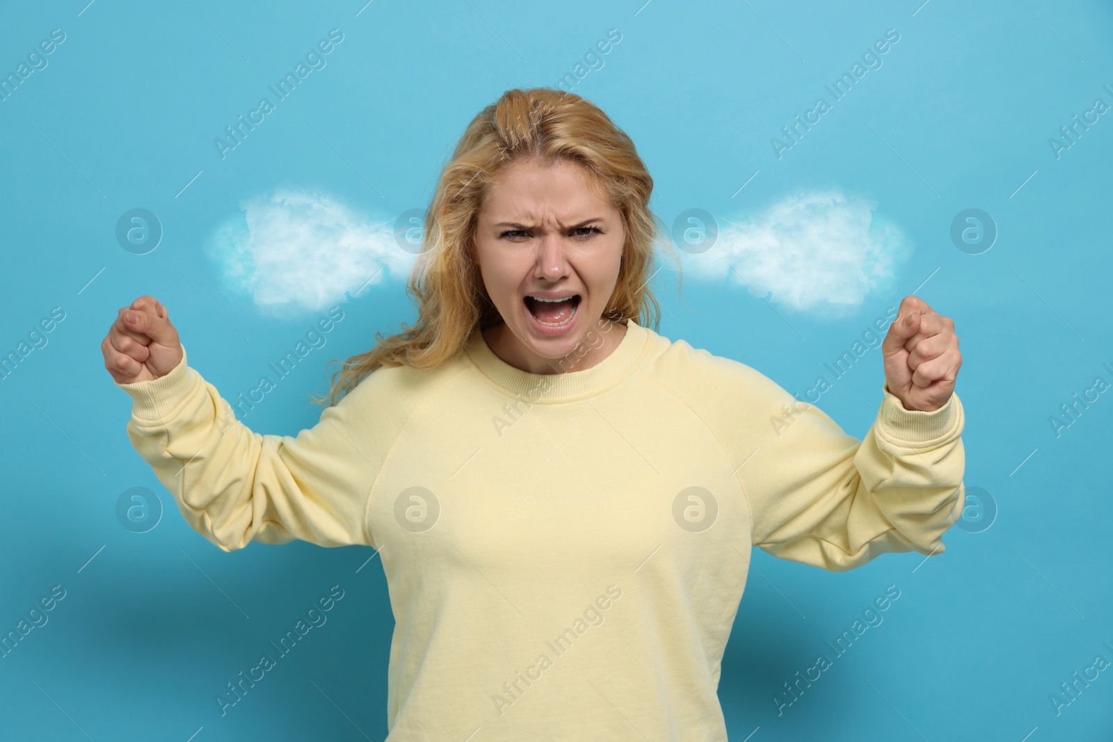 Image of Aggressive woman with steam coming out of her ears on light blue background