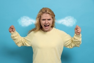 Image of Aggressive woman with steam coming out of her ears on light blue background