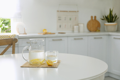 Photo of Lemonade on white table in modern kitchen. Interior design