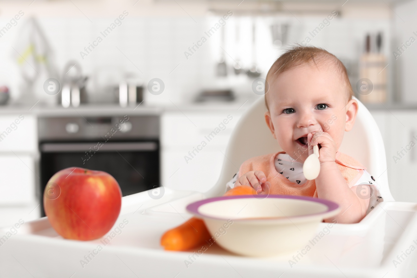 Photo of Adorable little child having breakfast in highchair indoors. Healthy baby food