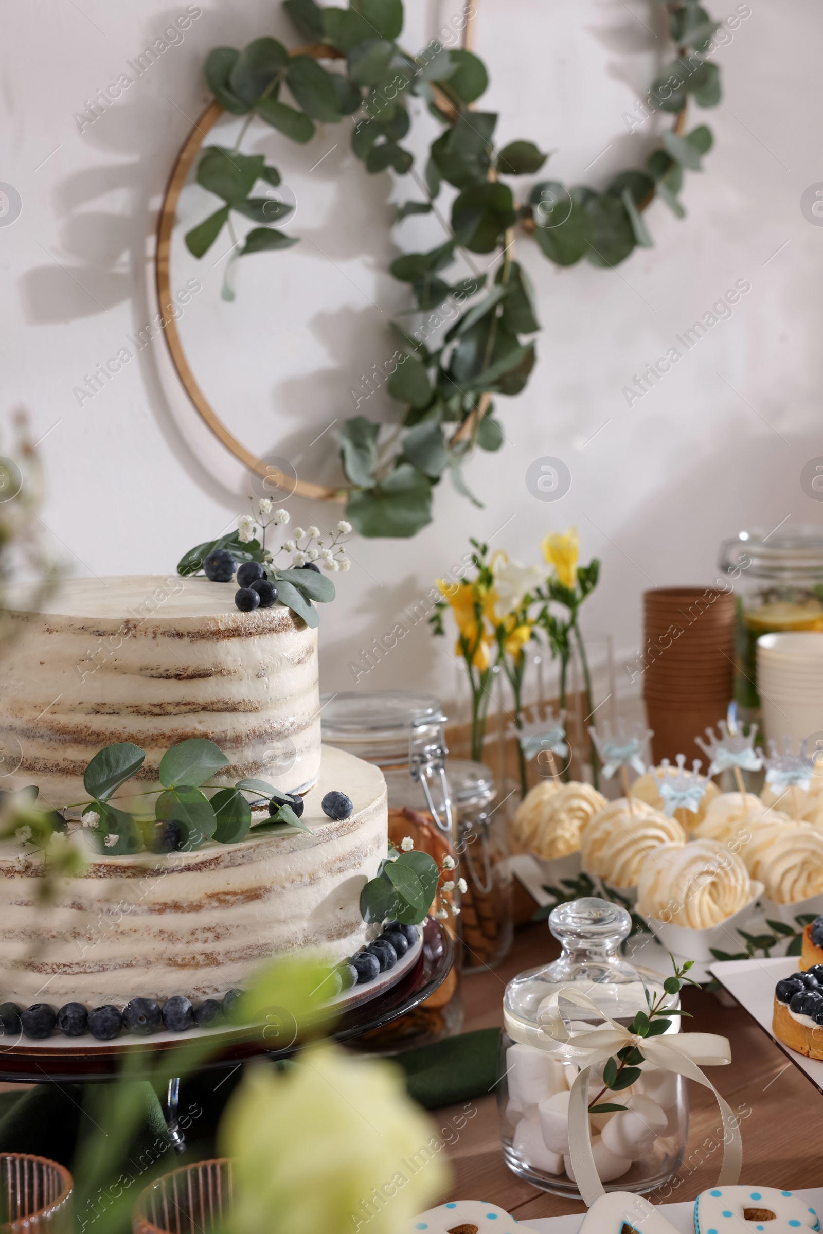 Photo of Beautiful cake and other treats on table in room. Sweet buffet