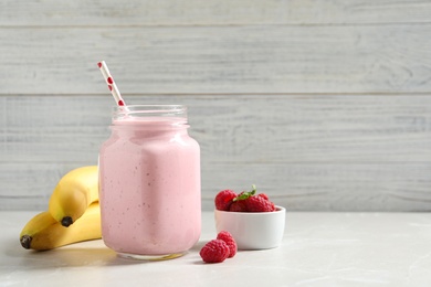 Image of Freshly made raspberry smoothie in mason jar on marble table