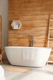 White tub and decor near wooden wall in room. Interior design