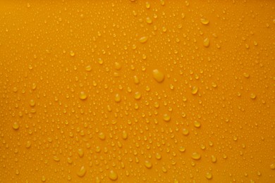 Many water drops on bright orange background