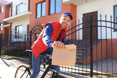 Photo of Male courier on bicycle delivering food in city