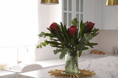 Bouquet with beautiful protea flowers on table in kitchen. Interior design