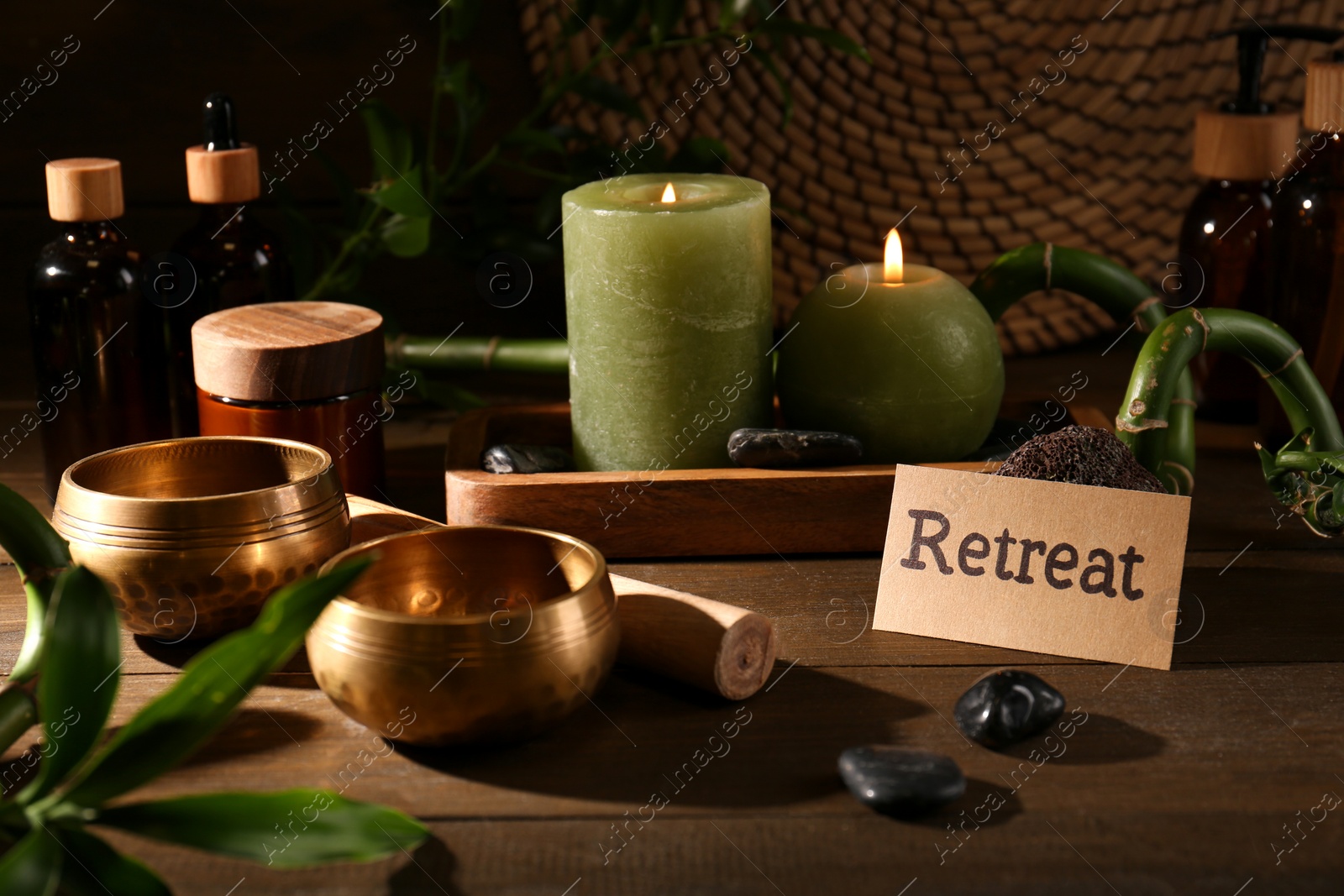 Photo of Card with word Retreat, singing bowls and burning candles on wooden table