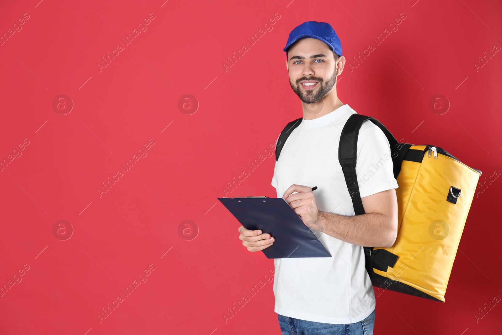 Photo of Courier with thermo bag and clipboard on red background, space for text. Food delivery service