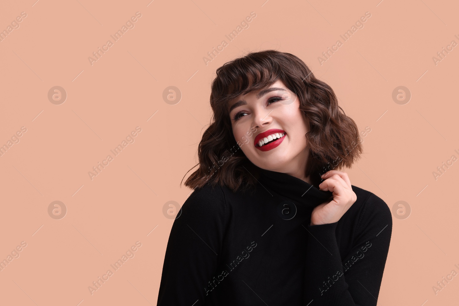 Photo of Portrait of beautiful young woman with wavy hairstyle on beige background. Space for text