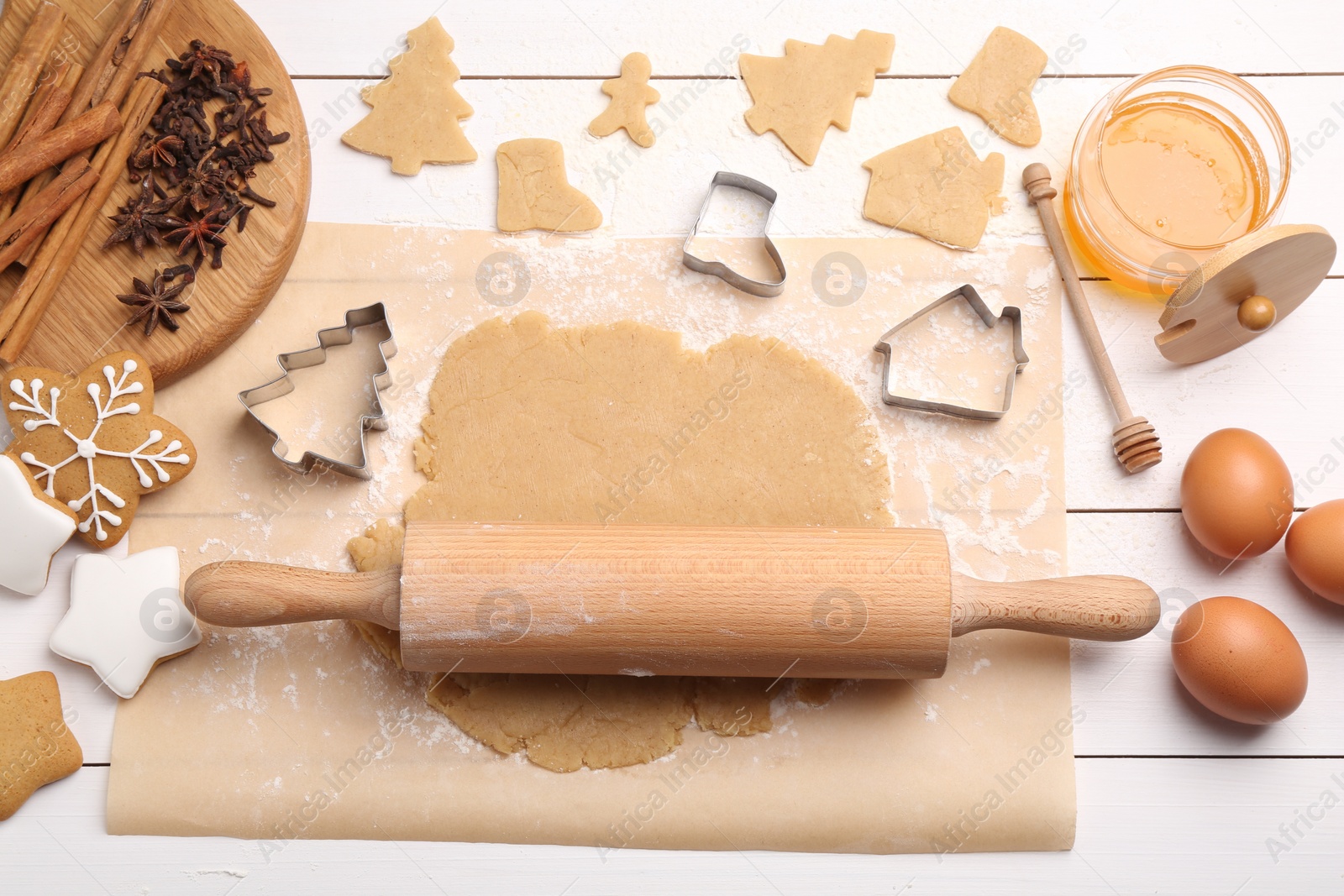 Photo of Making Christmas cookies. Flat lay composition with ingredients and raw dough on white wooden table