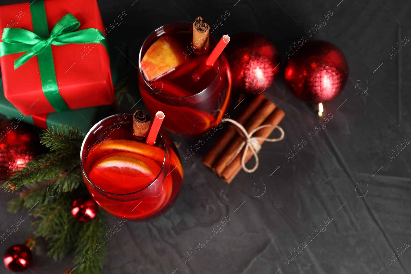Photo of Delicious Sangria drink in glasses and Christmas decorations on dark textured table, flat lay. Space for text