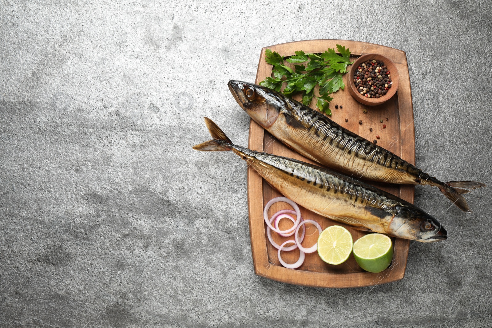 Photo of Tasty smoked fish on grey table, top view. Space for text