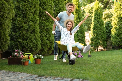 Happy couple having fun while working together in garden